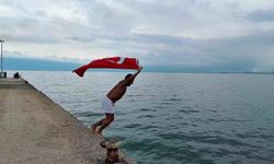 Soğuk ve yağışlı havaya aldırmadı, Türk bayrağıyla denize girdi