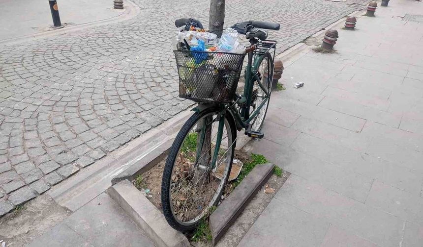 Aylardır ağaca kilitli duran bisikleti çöp kutusuna çevirdiler